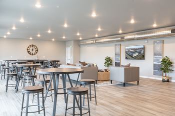 A communal area with stools and tables in the lobby of an office building